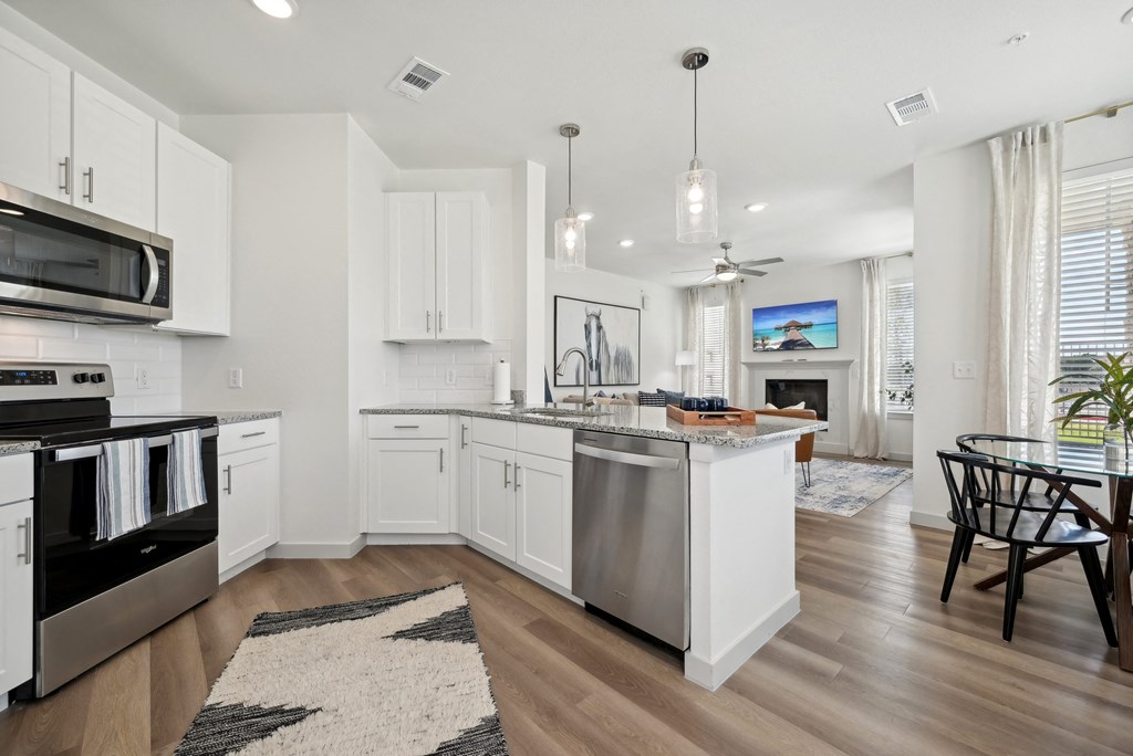 an open kitchen and living room with an island and a dining table