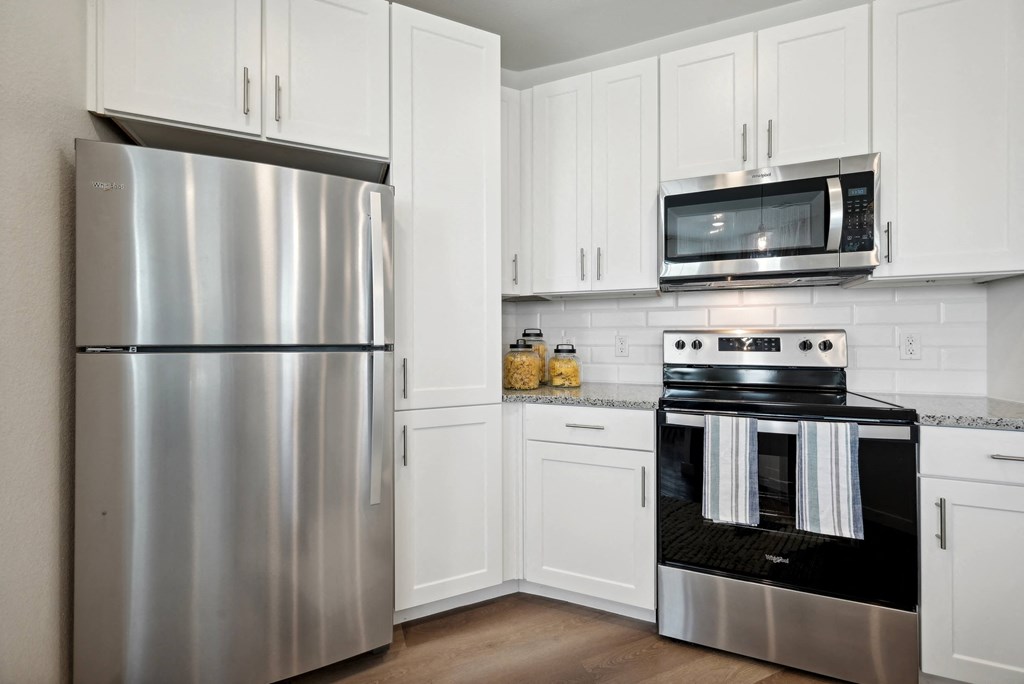 a kitchen with stainless steel appliances and white cabinets