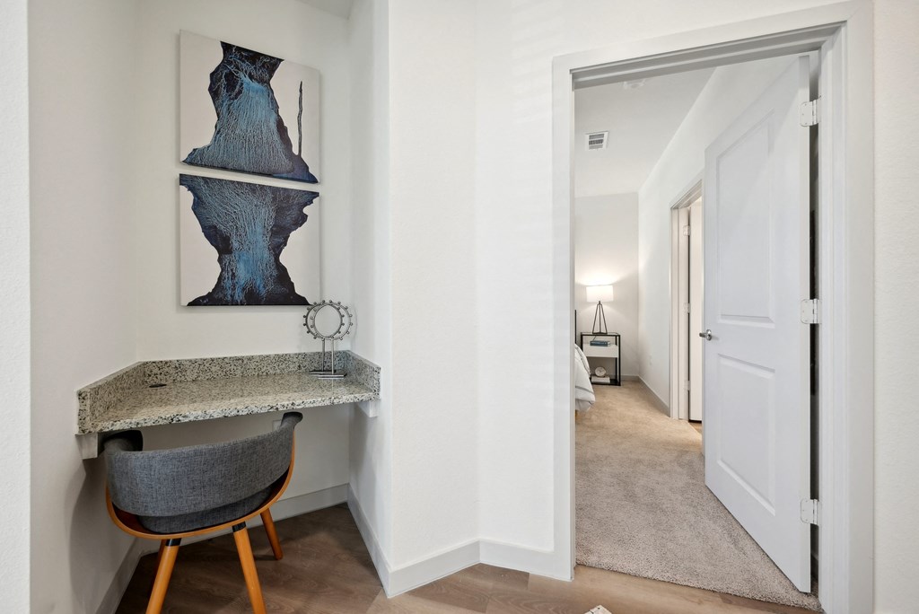 a hallway with a desk and a door to a bedroom