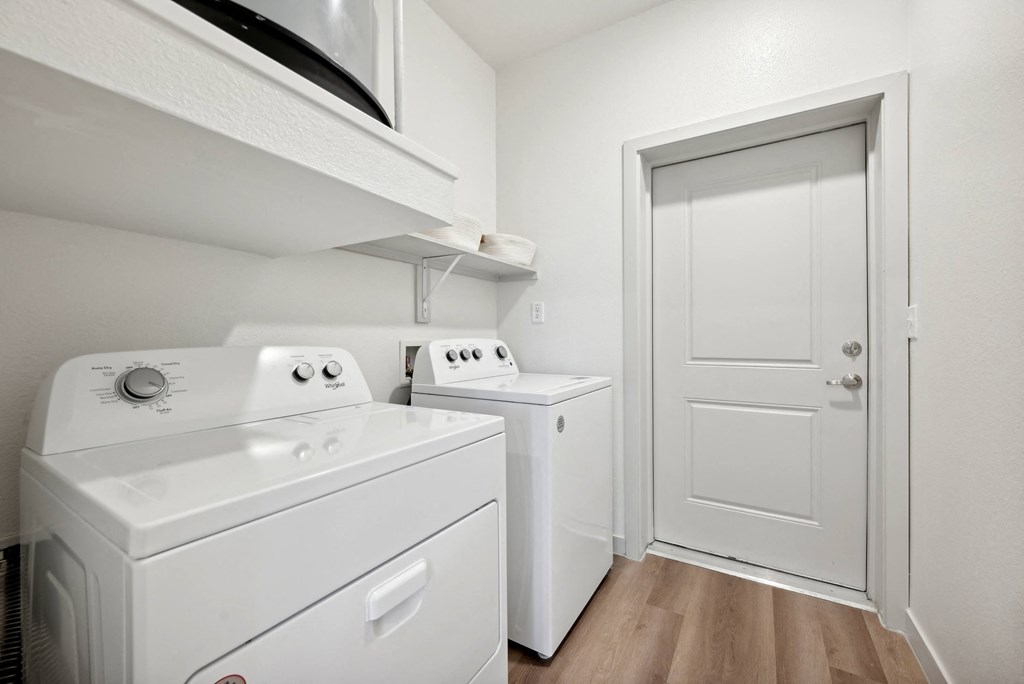a laundry room with a washer and dryer and a white door