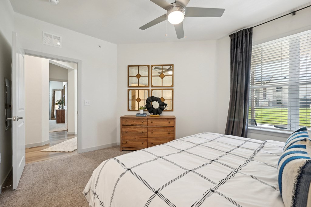 a bedroom with a large bed and a ceiling fan