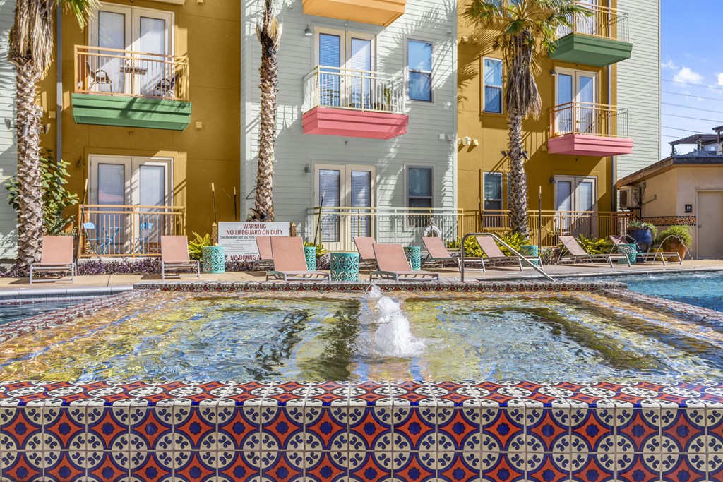 a pool with a fountain in front of a building
