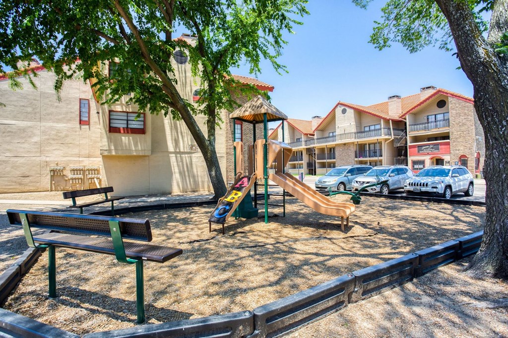 a playground with a slide and picnic table in a park