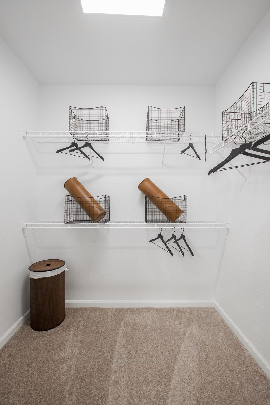 a room with wire baskets on the wall and a wooden stool on the floor