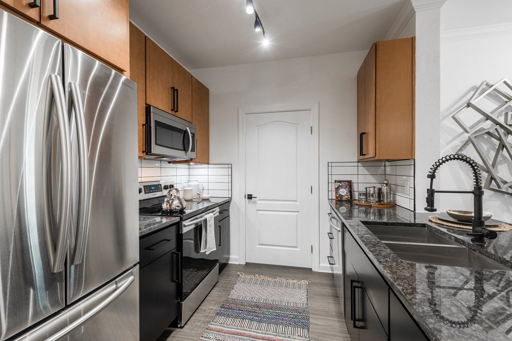 a kitchen with stainless steel appliances and granite countertops
