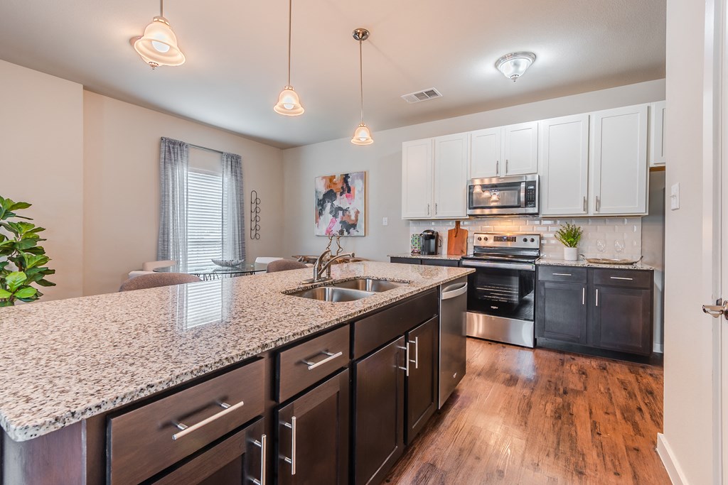 an expansive kitchen with granite counter tops and stainless steel appliances