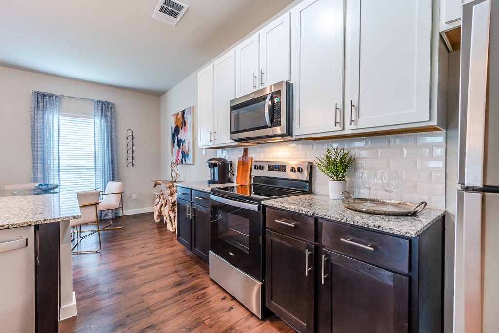 an updated kitchen with black appliances and white cabinets