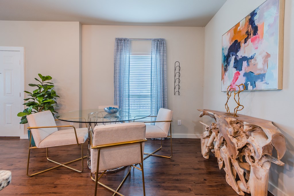 a dining room with a glass table and chairs