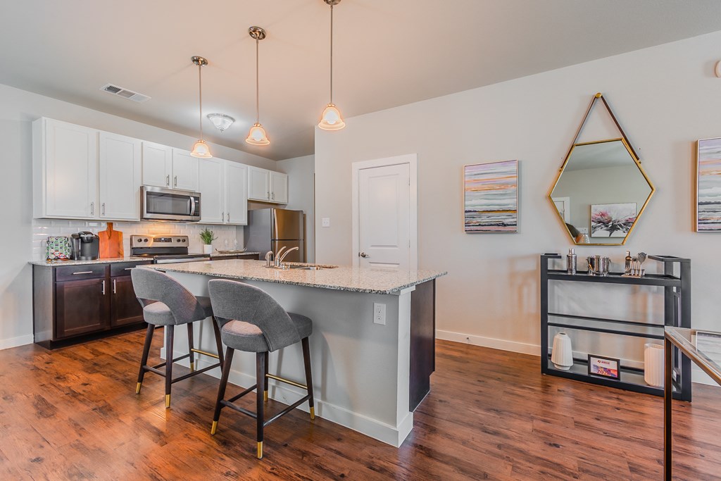 a kitchen with a bar and stools in front of a counter top