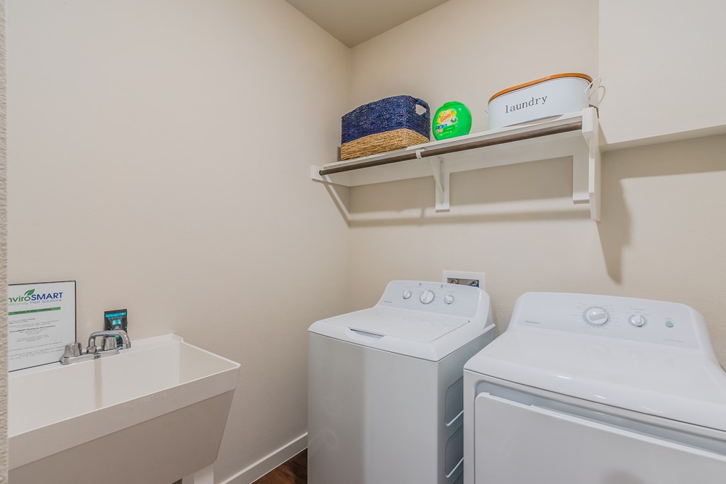 a washer and dryer in a laundry room with a sink