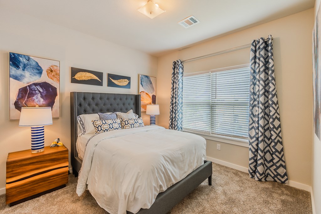 a bedroom with a bed and a large window