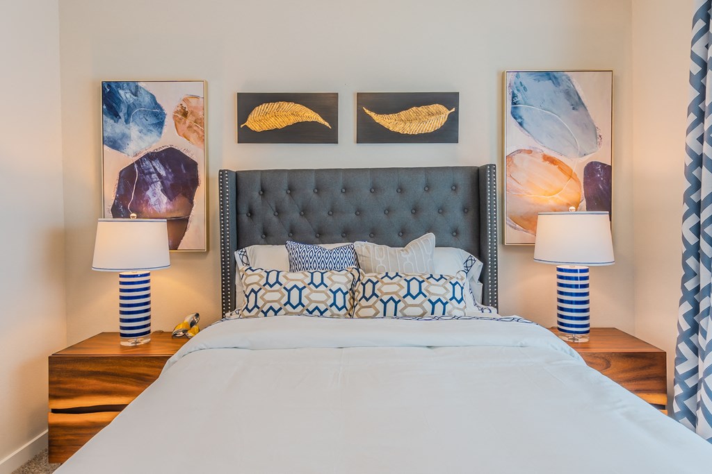 a bedroom with a large bed and paintings on the wall