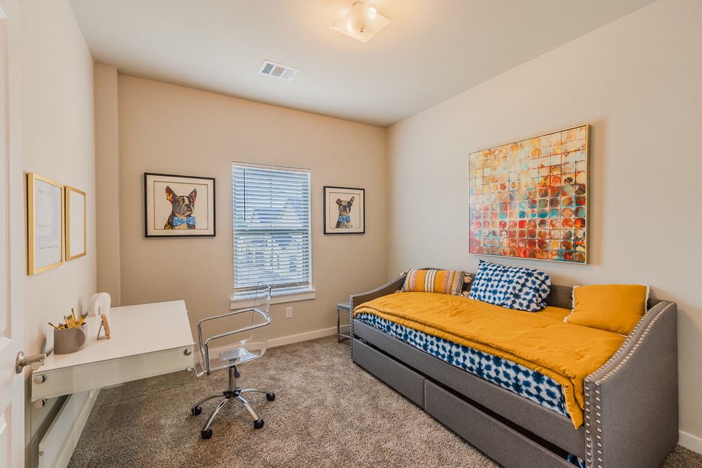 a bedroom with a bed and a desk and a window