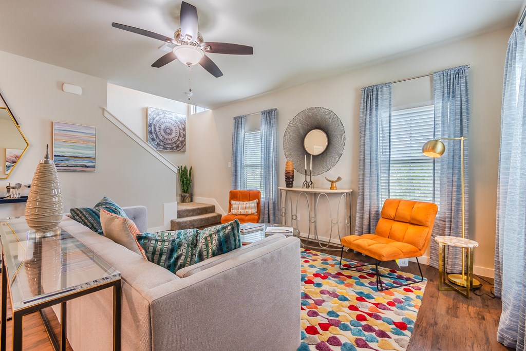 a living room with a couch and a ceiling fan