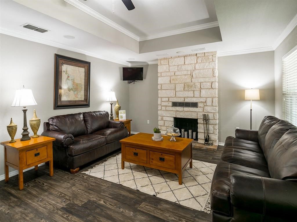 a living room with leather furniture and a stone fireplace