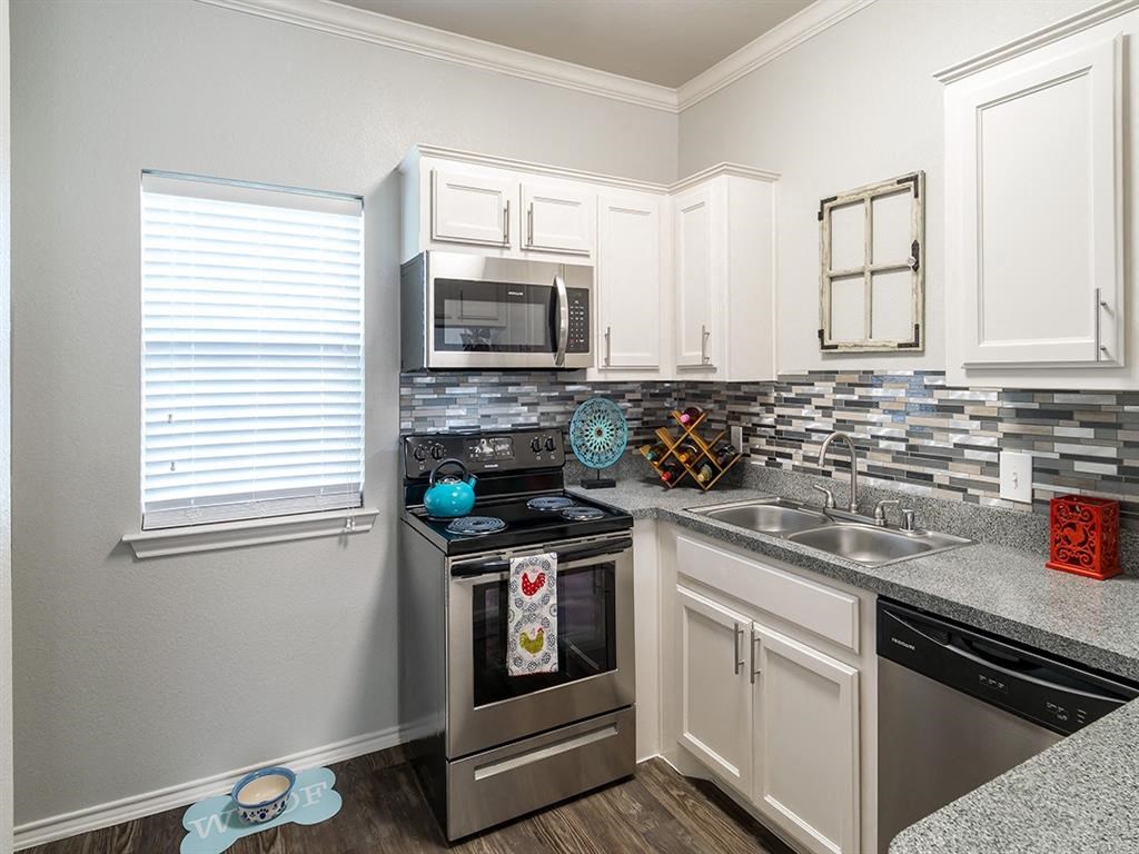 a kitchen with stainless steel appliances and white cabinets