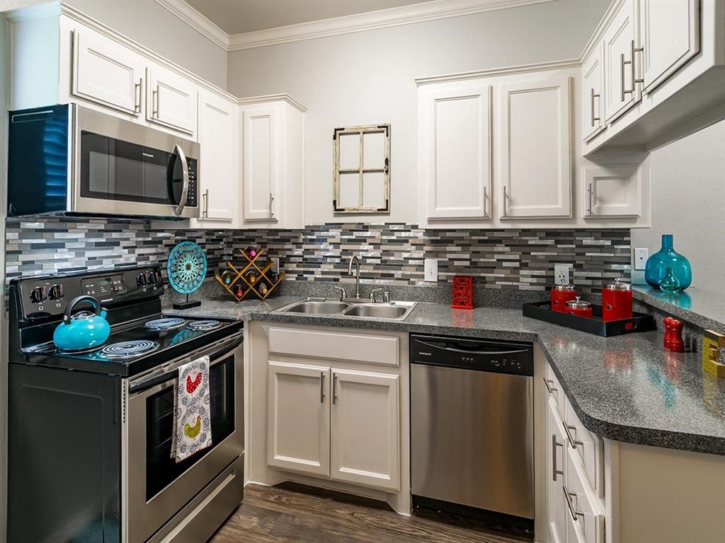 a kitchen with stainless steel appliances and white cabinets