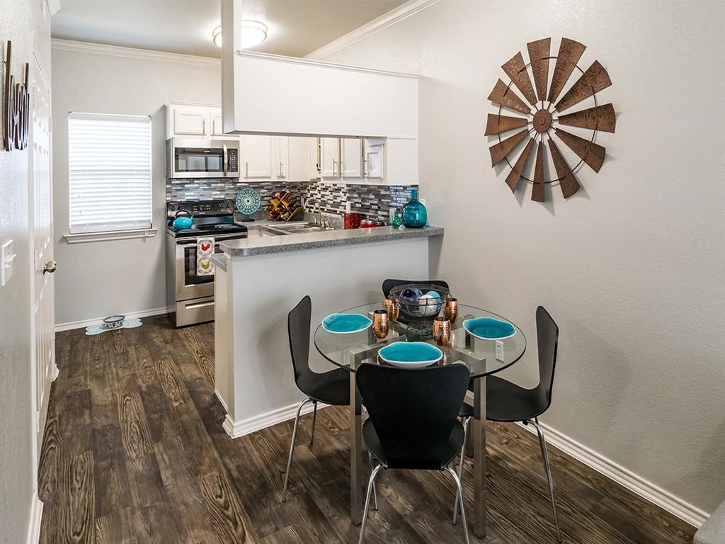 a dining room with a table and chairs next to a kitchen