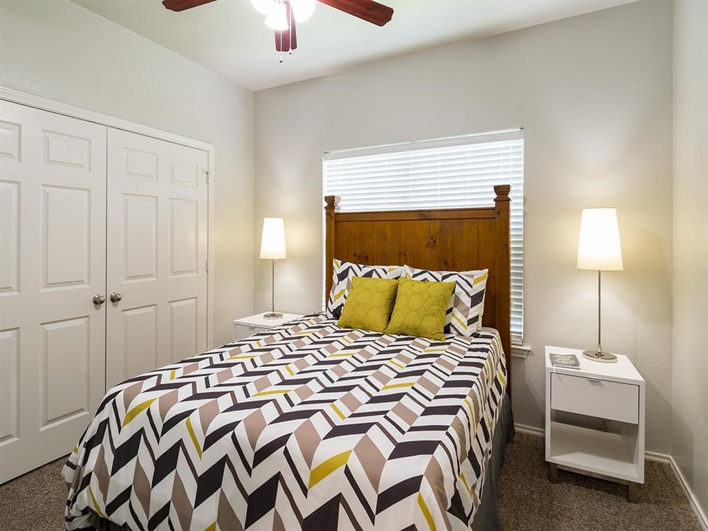 a bedroom with a bed and a ceiling fan