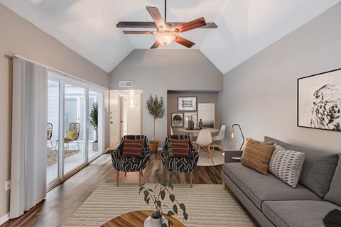 a living room with a couch and chairs and a ceiling fan