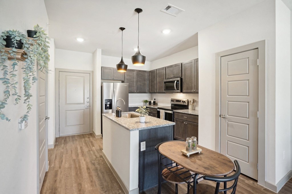 an open kitchen and dining area with a wood floor and white walls