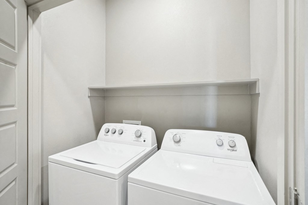 the laundry room of a home with two washes and a dryer