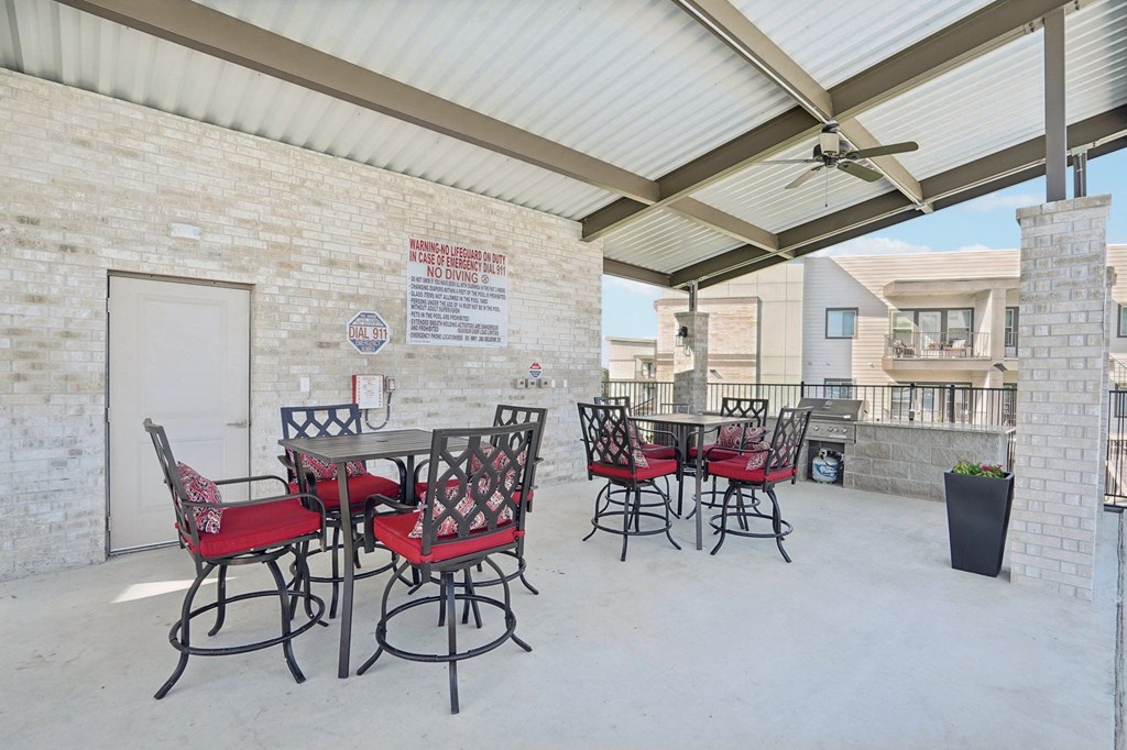 a patio with tables and chairs outside of a brick building