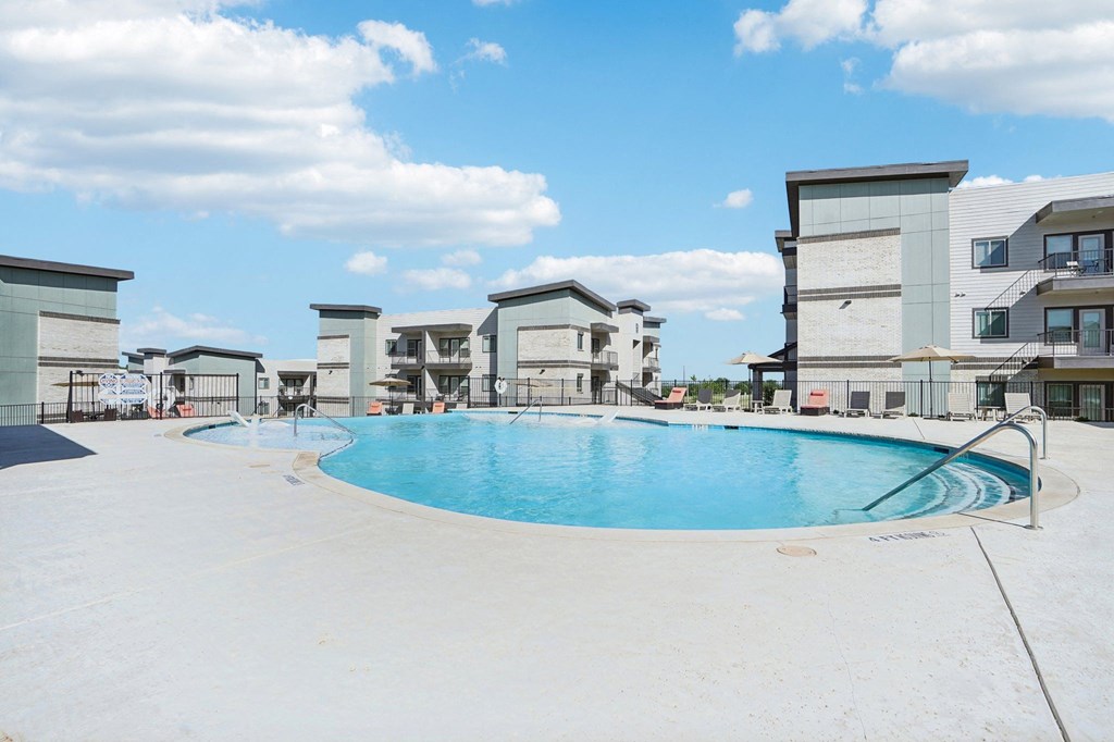 a large swimming pool with apartments in the background