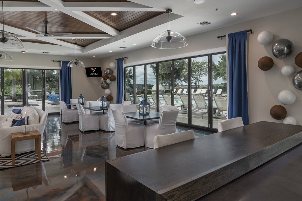a large living room with white chairs and blue curtains