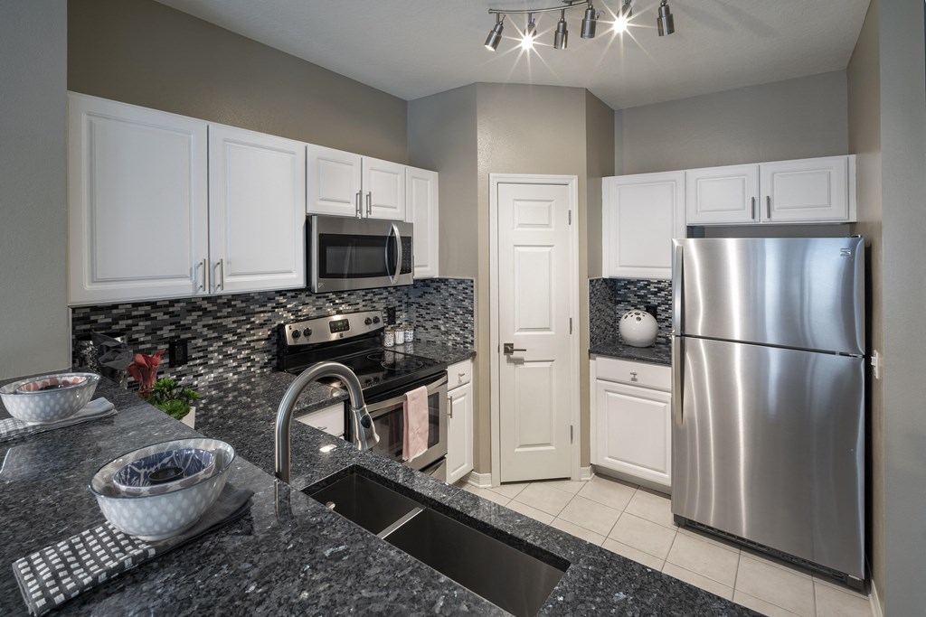 a kitchen with granite countertops and white cabinets