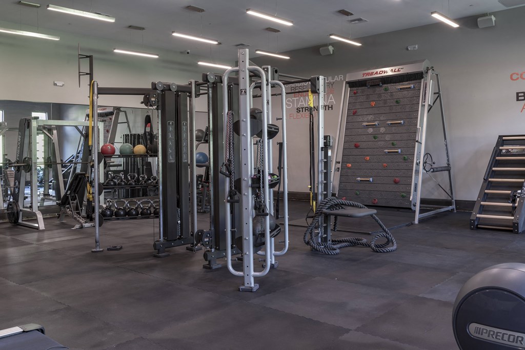 a view of the fitness center with a variety of exercise equipment