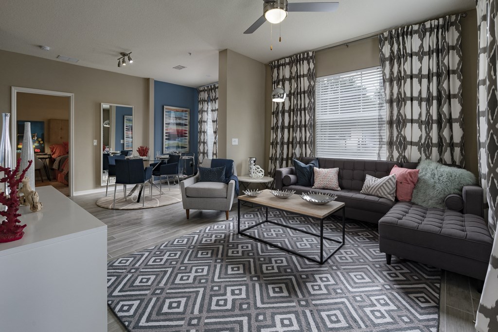 a living room with a couch chairs and a coffee table in front of a window