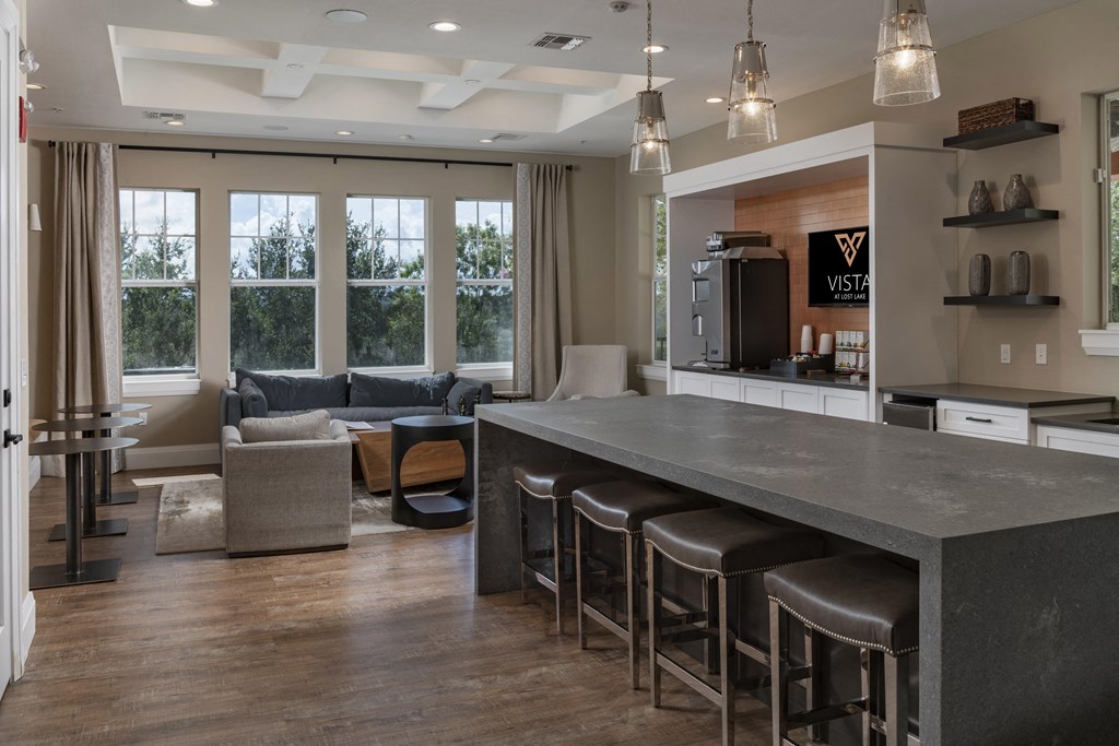 a kitchen with a long counter top and a living room in the background