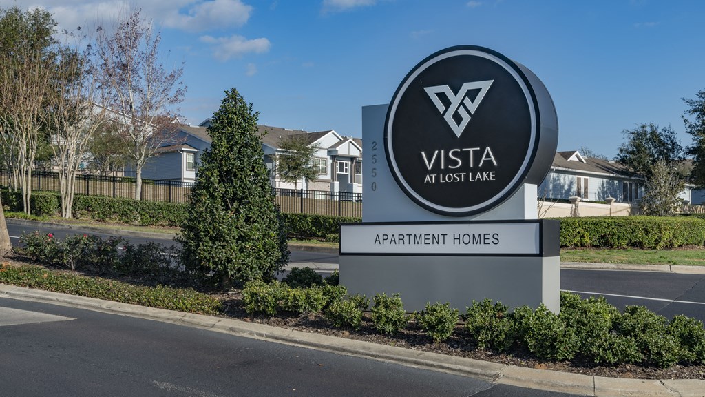 a sign for vista at lost line with houses in the background