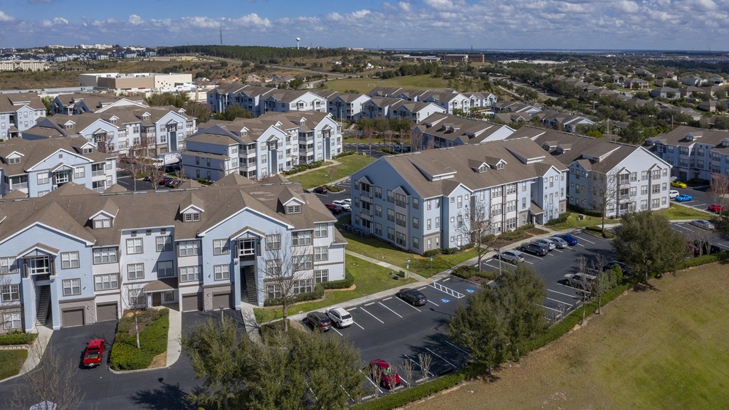an aerial view of a large apartment complex with cars parked in the parking lot