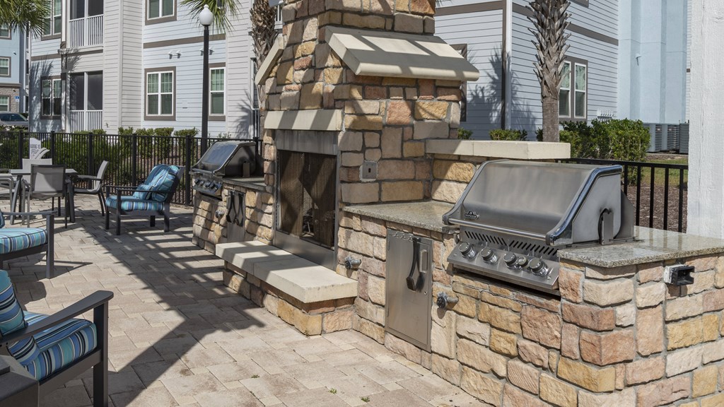 a backyard barbecue with a grill and seating area