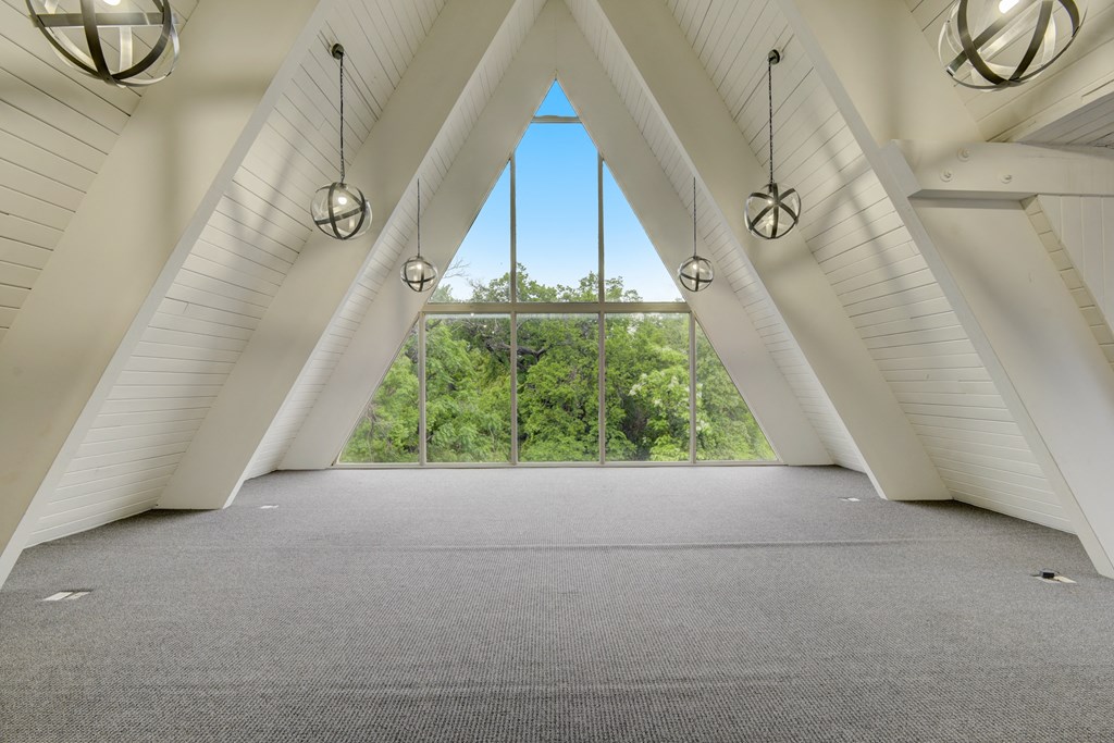an attic room with large windows and a view of trees