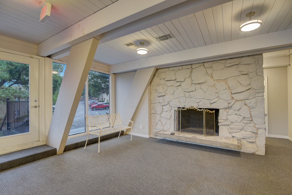 a living room with a stone fireplace and a window