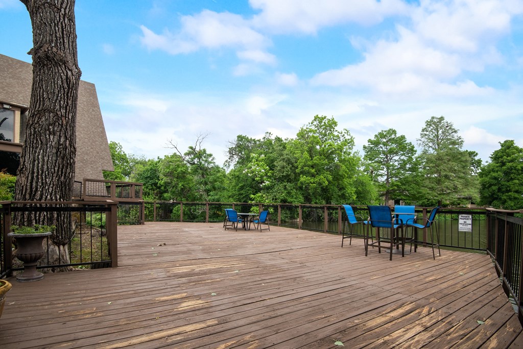 a deck with a tree and chairs on it