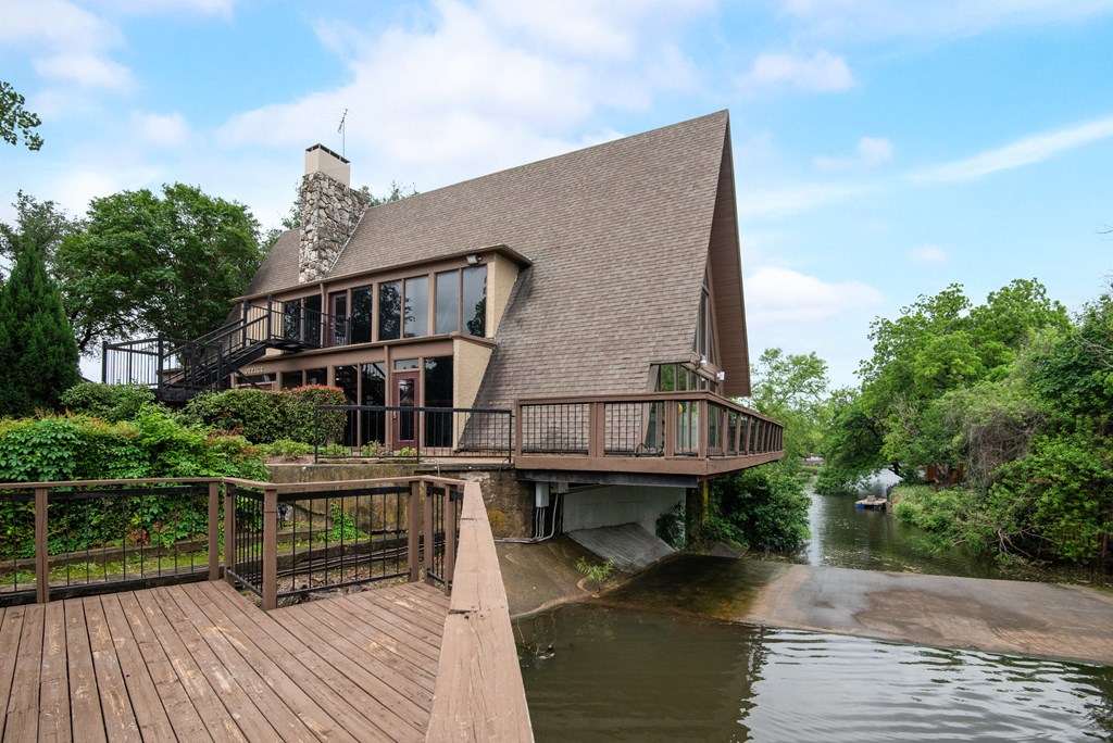a house on the water with a wooden deck