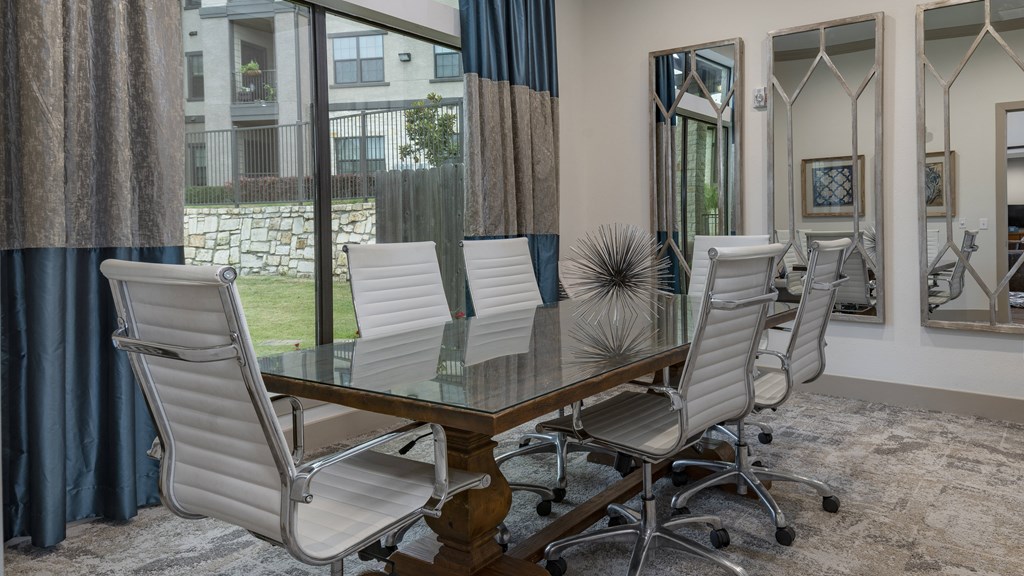 a dining room with a glass table and chairs