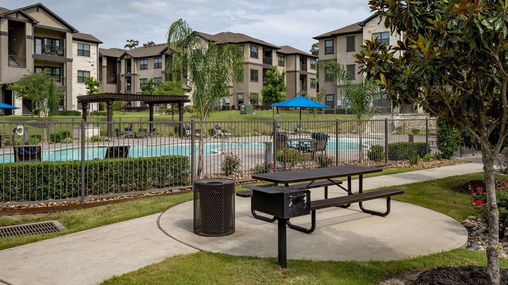 an outdoor amenities area with a picnic table and a pool