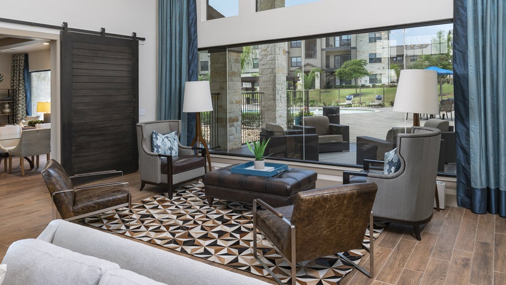 a living room with a couch and chairs and a large window