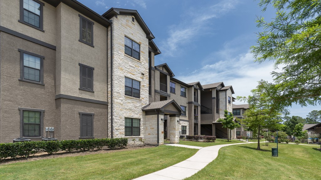 an apartment building with a sidewalk in front of it