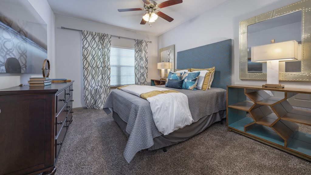 a bedroom with a large bed and a ceiling fan
