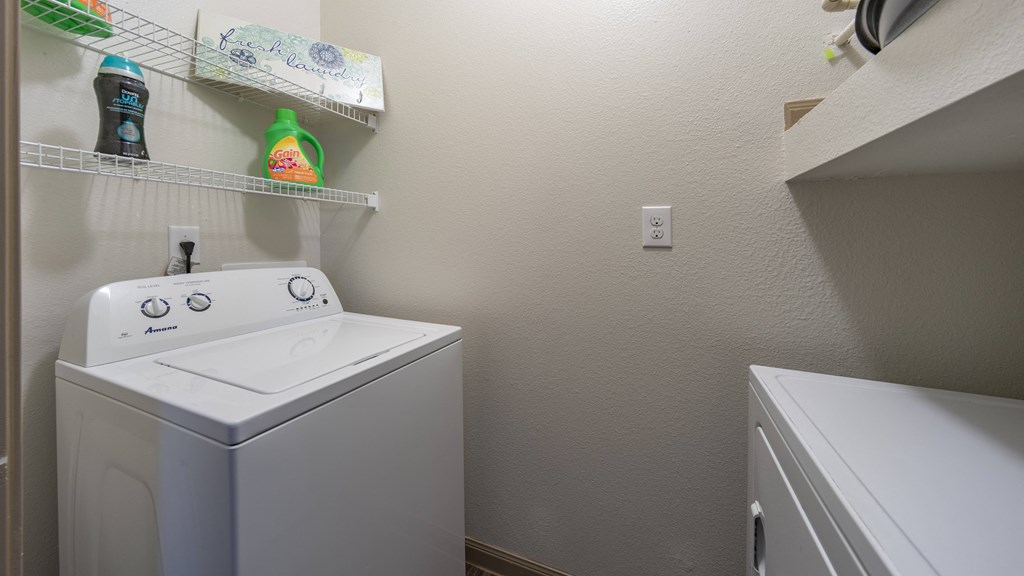 the laundry room has a washer and dryer and a shelf above the sink