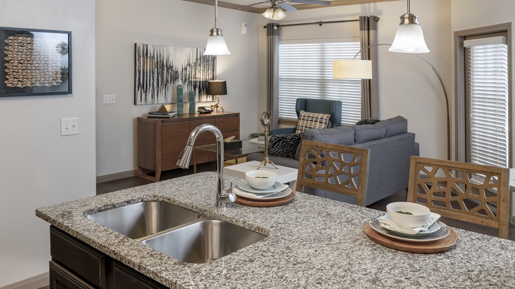 a kitchen with a sink and a counter top in a living room