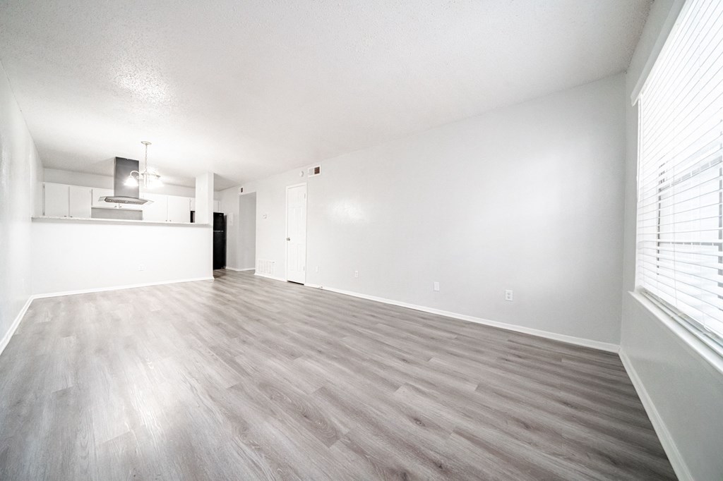 an empty living room with white walls and wood floors