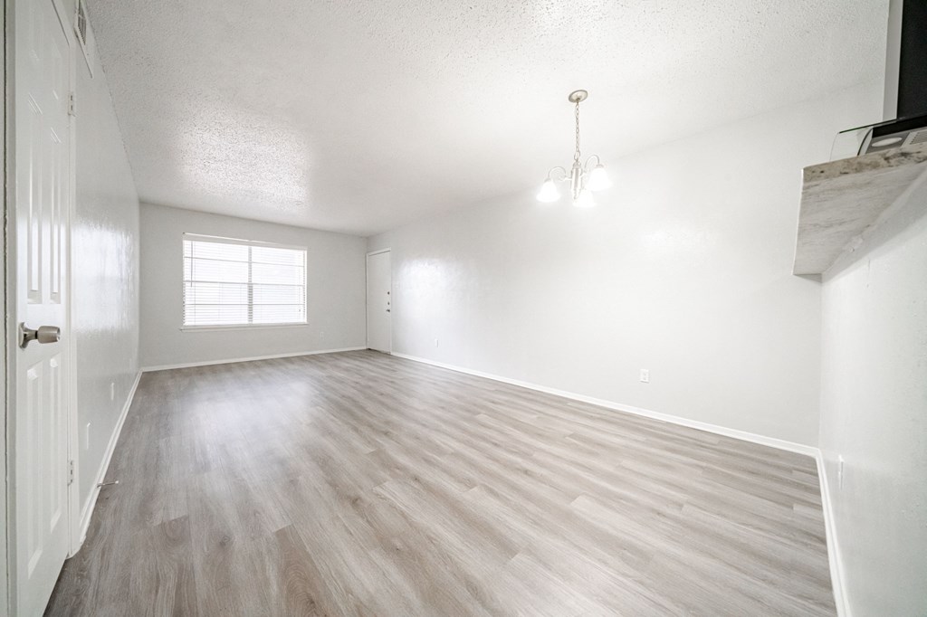 an empty living room with white walls and wood floors