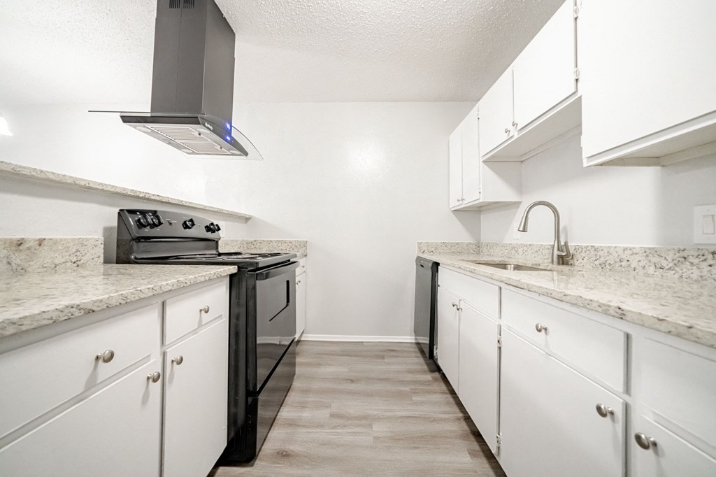 an empty kitchen with white cabinets and granite counter tops